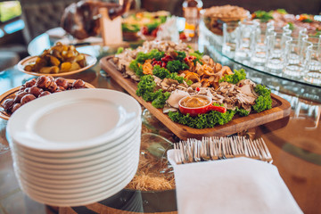 Buffet table of reception with cold snacks, meat and ham