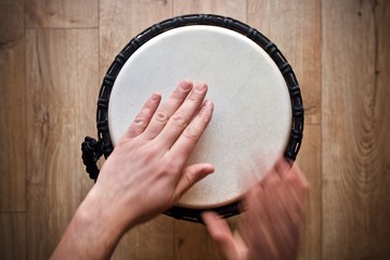 hands playing on djembe drum