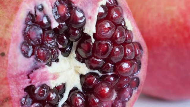 Lythraceae family pomegranate fruit with seeds 4K 3840X2160 UHD tilting video - Halved red healthy Punica granatum close-up slow tilt 2160p UltraHD footage 
