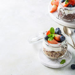 Gluten free breakfast with red quinoa, yogurt and berries in glass jar. Healthy super foods concept with copy space.