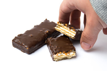 Male hand taking chocolate wafers dessert on white