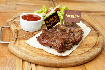 cooked steak on a wooden board