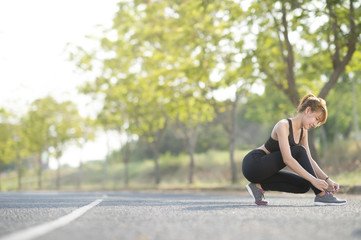 Fototapeta na wymiar Asian young woman runner tying shoelaces healthy lifestyle jogging