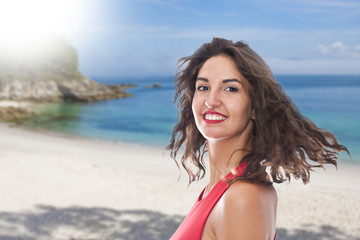 Naklejka premium portrait of smiling young woman on the beach