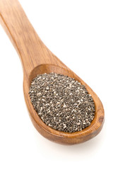 Whole dried black chai seeds in wooden spoon
