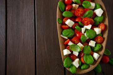 caprese salad on dark wooden surface