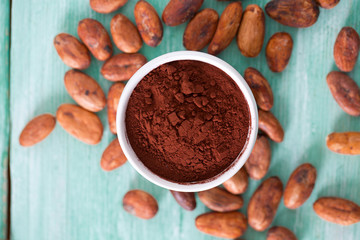 cocoa powder and beans on turquoise surface