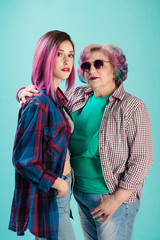 Young girl, senior woman in colorful clothes and hairstyle. Hipster