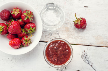 Strawberry jam in a jar on wooden background