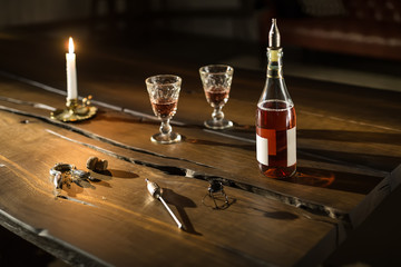 Bottle with glasses and accessories on table