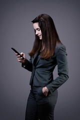 Portrait d'une jeune femme d'affaires souriante écrivant un sms