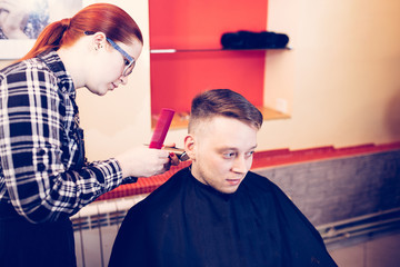 young attractive woman hairdresser make hairstyle for man