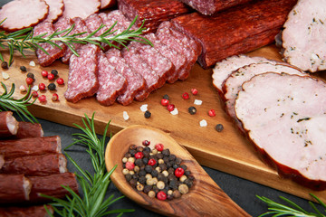 Set of cold cuts on a wooden board. Mix of sausages