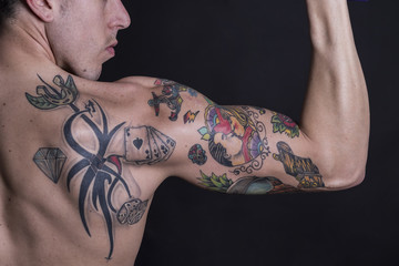 Brazo masculino fuerte muestra bíceps y tatuajes