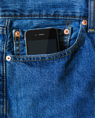 Modern smart phone in front pocket of blue denim jeans. Closeup.