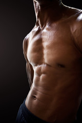 Fototapeta na wymiar Man abdominal muscles isolated black background