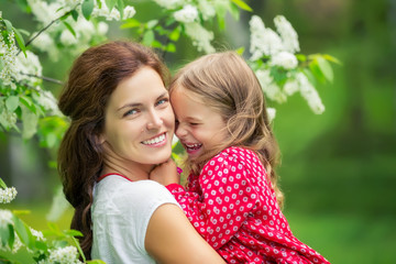 Portrait of happy mother and little daughter in spring park