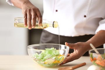 Chef cooking tasty salad in kitchen, closeup