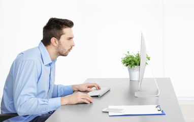 Incorrect posture concept. Man sitting at office table