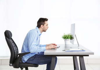 Incorrect posture concept. Man sitting at office table