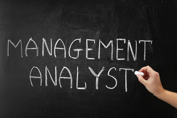 Obraz premium Hand writing phrase MANAGEMENT ANALYST on blackboard