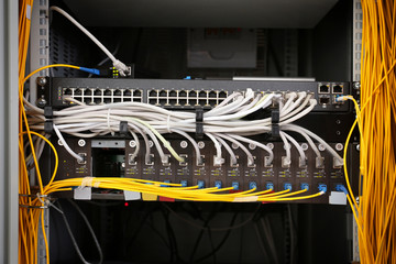 View of open cabinet with wires in server room, closeup