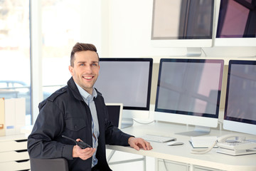 Handsome security guard in surveillance room