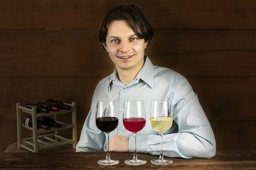 Enologist tasting wine at winery, with three glasses