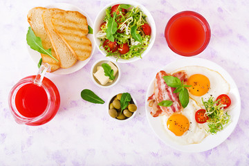 English breakfast - fried egg, tomatoes and bacon. Flat lay. Top view