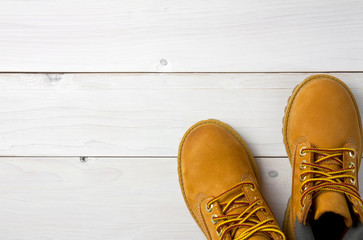 brown or yellow boots shoes for foot and adventure travel place on vintage white floor or table with copy space