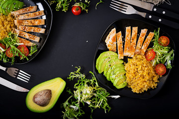 Healthy dish with chicken, tomatoes,  avocado, lettuce and lentil on dark  background. Dinner . Flat lay. Top view