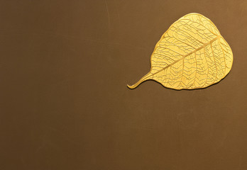 gold bo leaf metal plate on brown wall for decor and background with copy space