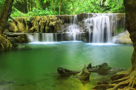 waterfall with clear green emerald water and rock for relax with tree and root in the jungle or forest at Huay Mae Khamin waterfall for nature landscape and background