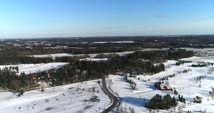 Bodomintie, Cinema 4k aerial view of a flight above a winter road and landscape, near lake Bodom, in Espoo, Finland