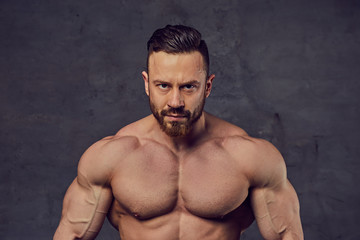 Fototapeta premium Shirtless bearded bodybuilder over grey background.