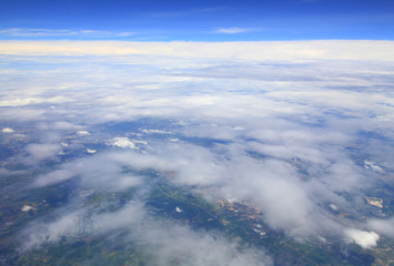 Aerial photo of land and clouds from above.
