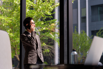 Asian smart business man calling on the smarphone in his office.