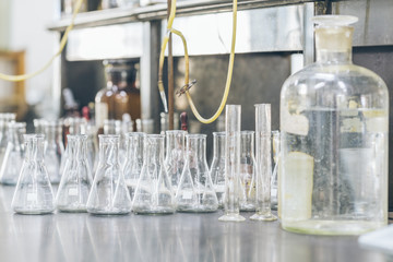 detail shot of beakers and equipment on table in factory laboratory.