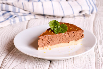 Chocolate cheesecake, decorated mint on a white plate, horizontal