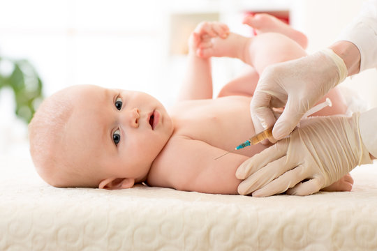 Pediatrics doctor giving a child vaccine injection