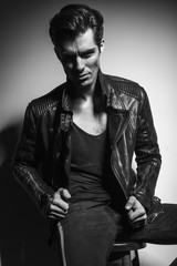 young man in leather jacket pulling collar
