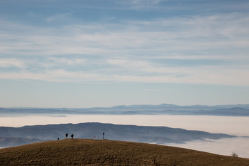 A couple on top of a mountain looking at a sea of fog