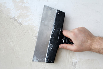 Spatula in hand. Interior trim. The puttying of the walls.