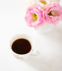 Still life with  cup of coffee  and flowers (Eustoma).  Selective focus. Shallow depth of field.