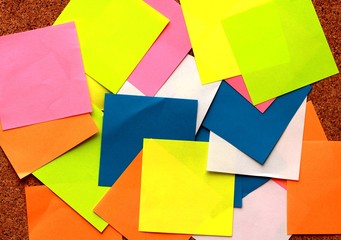 Colorful sticky notes with pin on a cork board