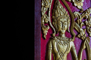 The carved door panels are beautifully decorated with gilded black lacquer, Chiang Mai, Thailand