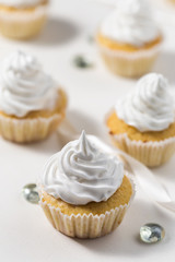 Vanilla cupcakes white white whipped cream on a white table