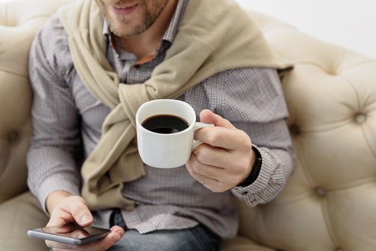 Joyful guy messaging on mobile phone