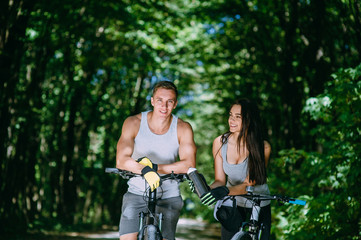 Obraz premium Young Couple Riding Bike In Park
