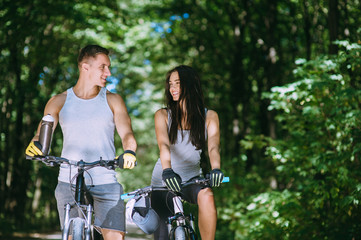 Obraz premium Young Couple Riding Bike In Park